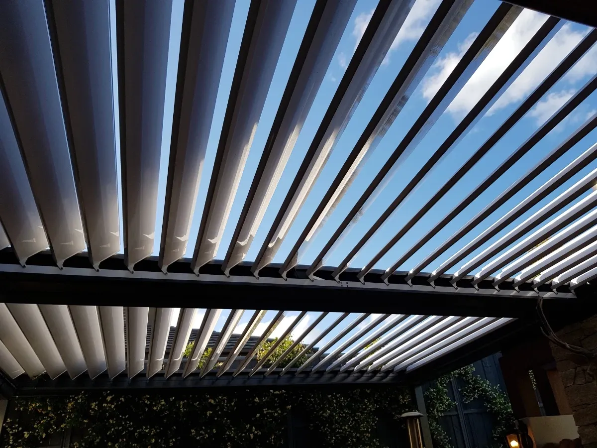 Louvred patio with adjustable roof blades over an outdoor lounge